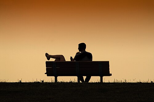 Two people sitting close on a bench